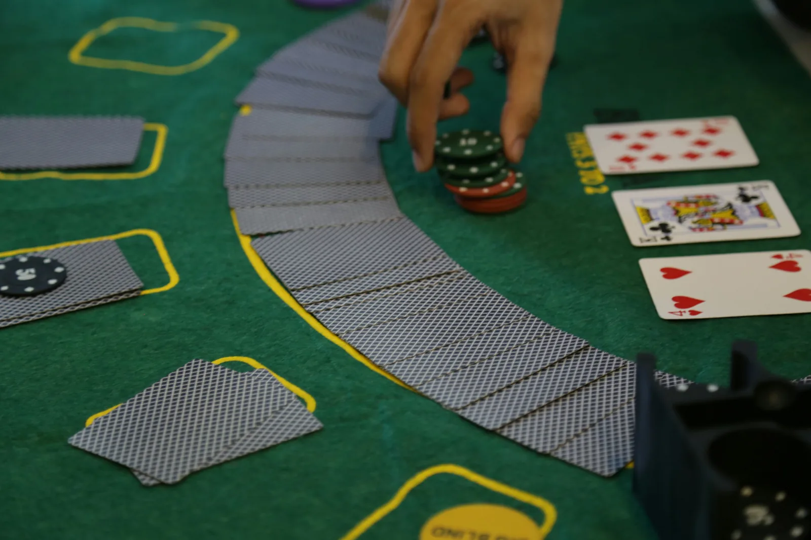 Playing cards and casino chips arranged on a blackjack table felt
