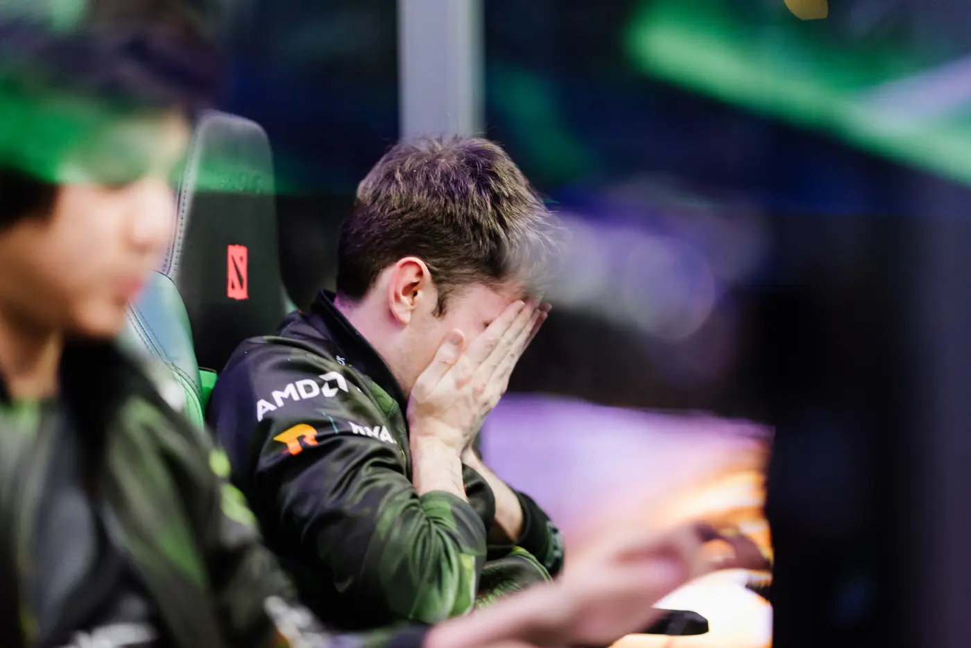 A Dota 2 player with his head in his hands after losing a series